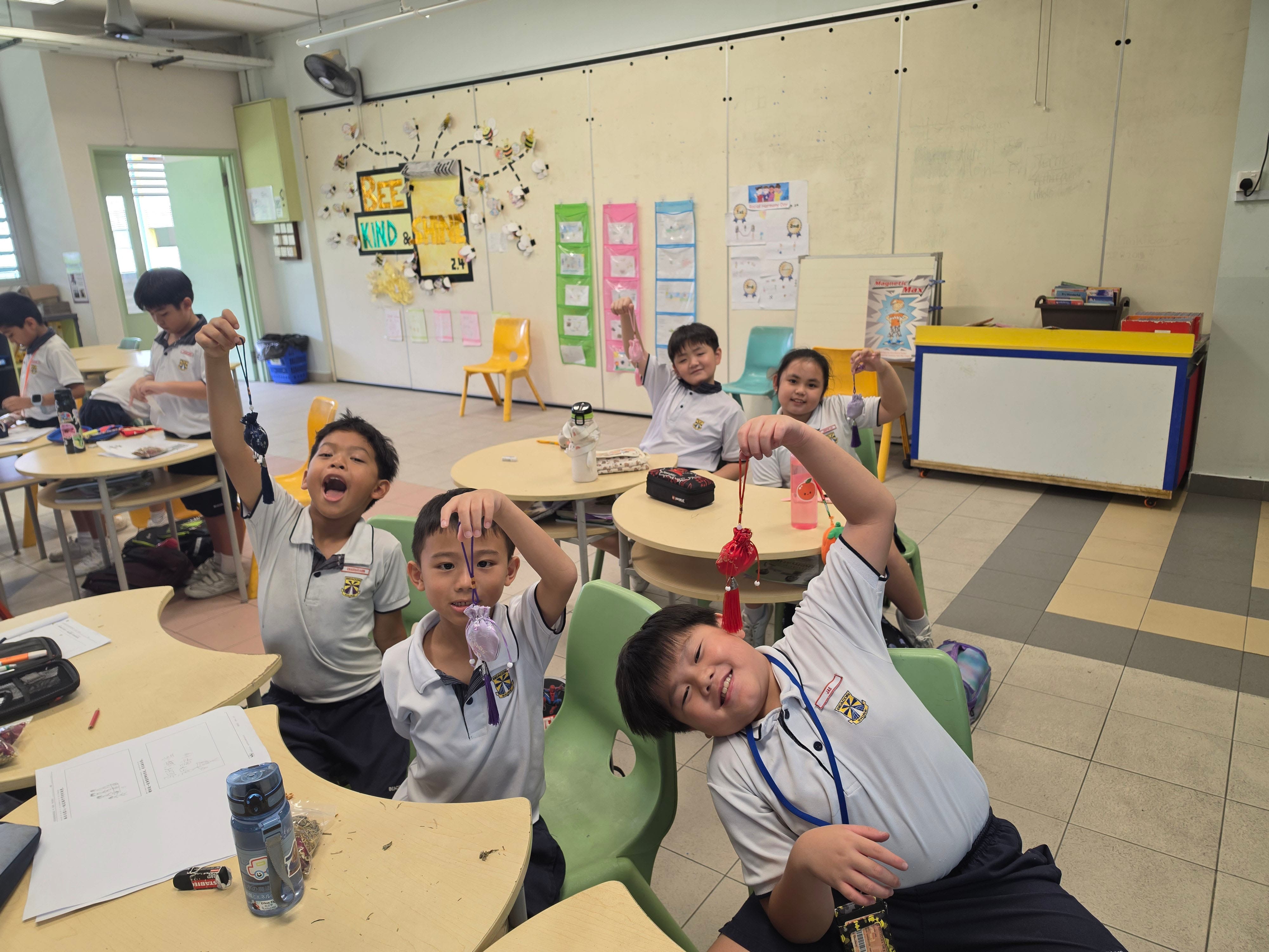 P2 CL students proudly showcasing the fragrant sachets (香囊) they handcrafted during the Chinese cultural workshop.